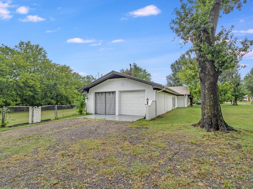 203 Hogg Street Streetman, TX 75859 - Photo 7 of 36 a view of a house with a yard and large trees