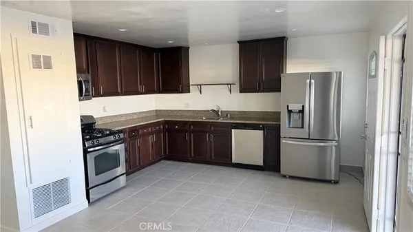 a kitchen with stainless steel appliances granite countertop a stove a refrigerator and a sink