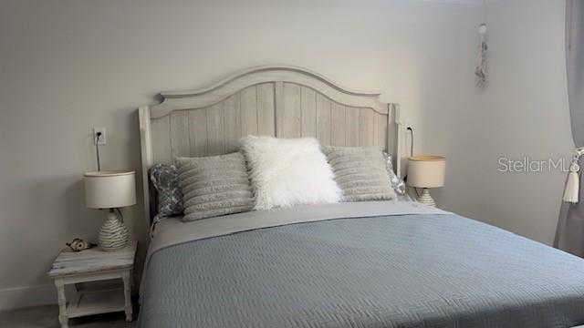 403 63rd Street Holmes Beach, FL 34217 - Photo 20 of 81 a bedroom with a bed and a lamp on dresser