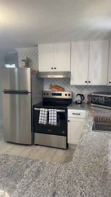 403 63rd Street Holmes Beach, FL 34217 - Photo 32 of 81 a kitchen with a stove a refrigerator and a sink