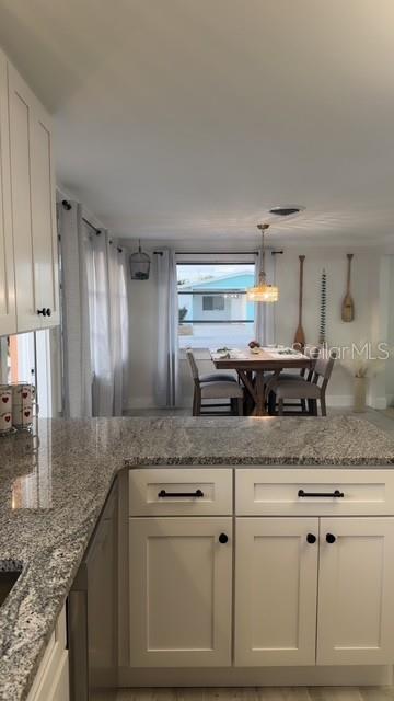 403 63rd Street Holmes Beach, FL 34217 - Photo 35 of 81 a kitchen with granite countertop a sink and cabinets