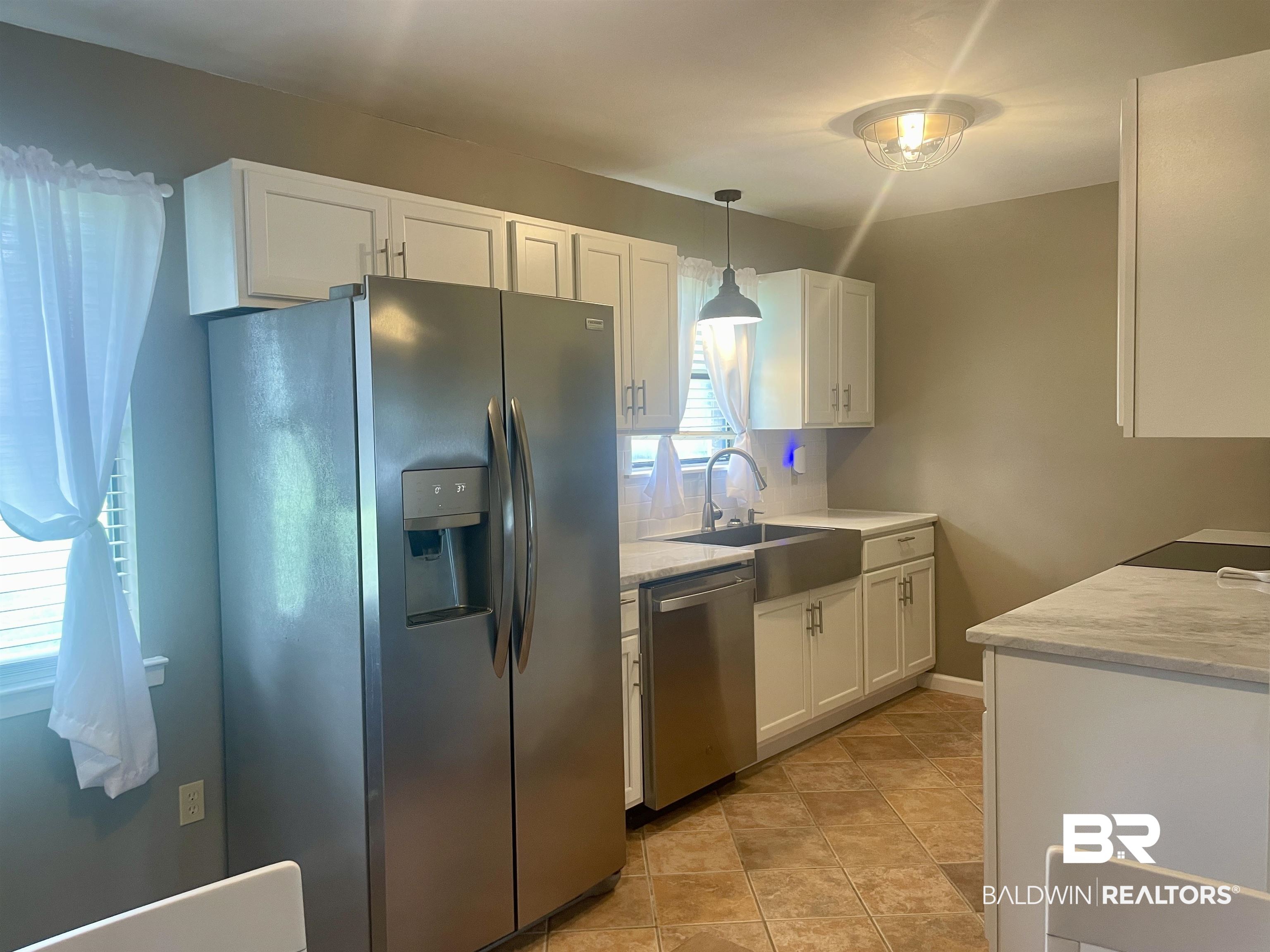 2274 Foshee Road Brewton, AL 36426 - Photo 9 of 23 Kitchen featuring appliances with stainless steel finishes, white cabinetry, pendant lighting, and light stone counters
