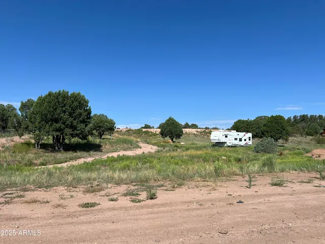 a view of a dirt road with a building in the background