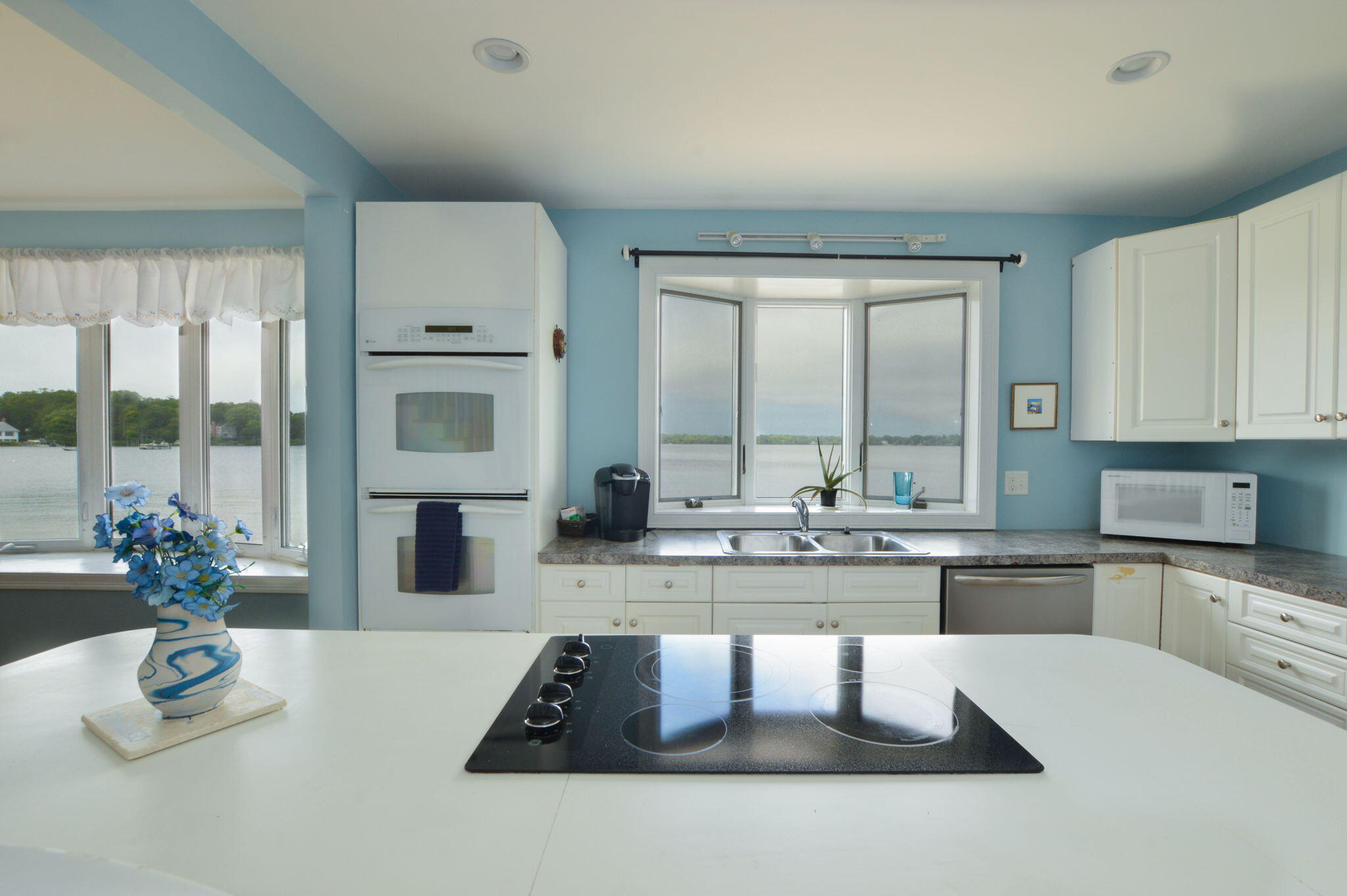 97 Willow Run Drive Centerville, MA 02632 - Photo 10 of 30 a kitchen with kitchen island granite countertop a stove a sink a dining table and chairs
