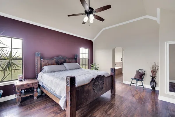 a bedroom with a bed a chair and a large window