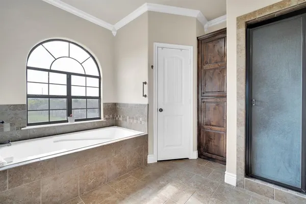 an empty room with large windows and a chandelier