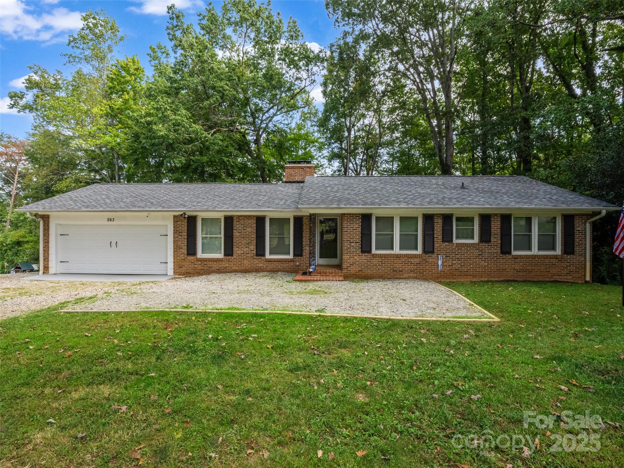 263 Blanton Street Columbus, NC 28722 - Photo 1 of 45 a front view of a house with a yard and garage