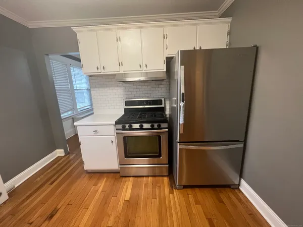 a kitchen with wooden floors and appliances