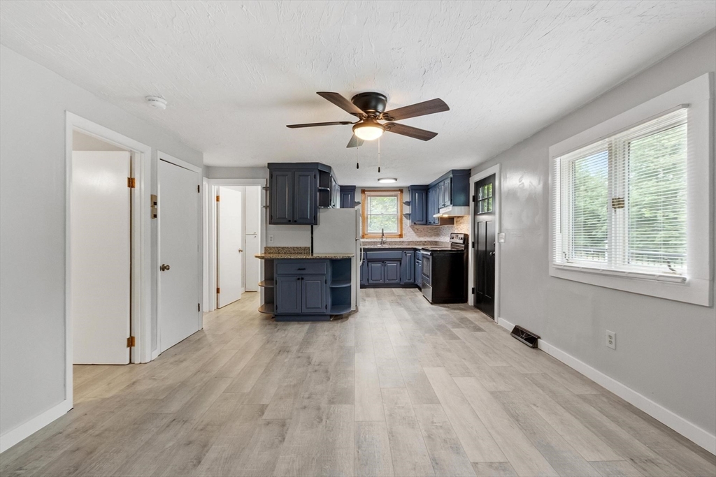 258 Allen Road Ashby, MA 01431 - Photo 9 of 36 a large white kitchen with stainless steel appliances kitchen island granite countertop a refrigerator and a sink