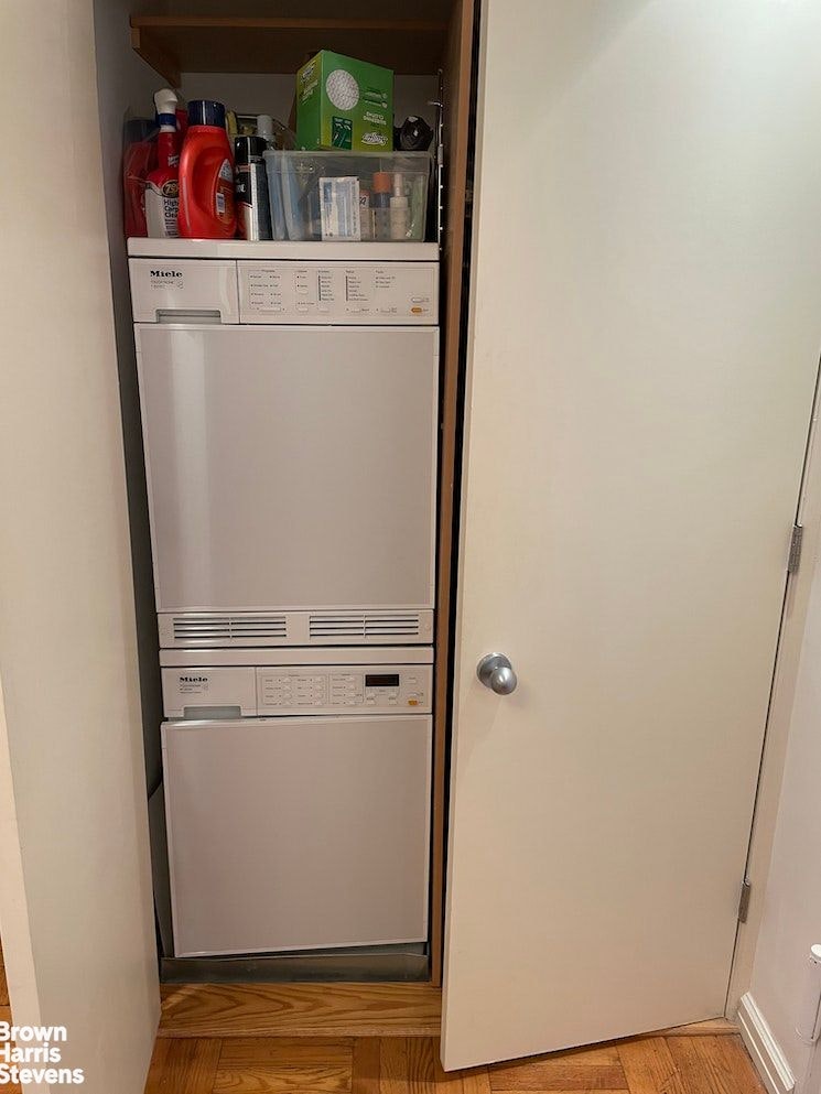 150 East 61st Street, Unit 5F Manhattan, NY 10065 - Photo 10 of 15 storage and utility room with washer and dryer