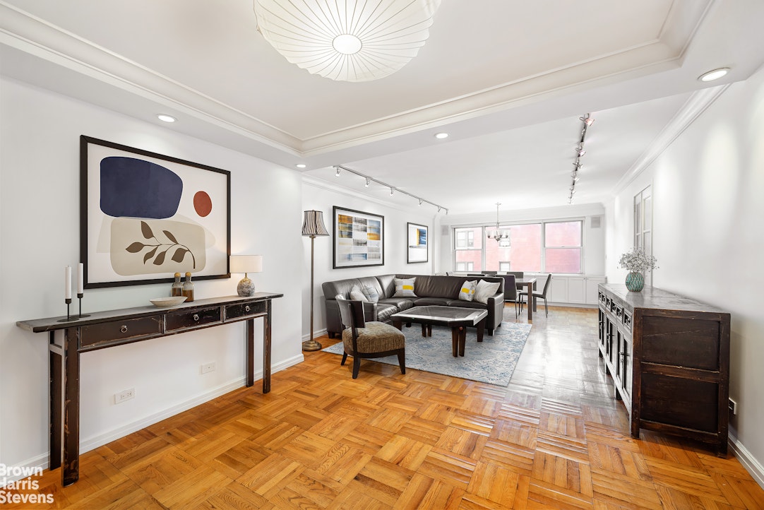 150 East 61st Street, Unit 5F Manhattan, NY 10065 - Photo 2 of 15 a living room with furniture and a flat screen tv