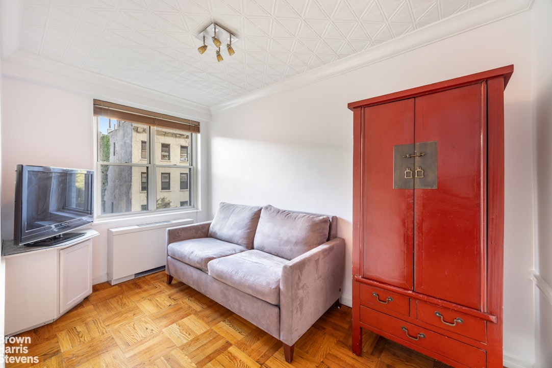 150 East 61st Street, Unit 5F Manhattan, NY 10065 - Photo 5 of 15 a living room with furniture a flat screen tv and windows