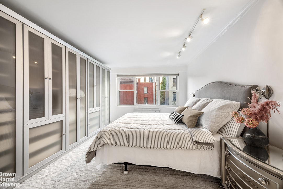 150 East 61st Street, Unit 5F Manhattan, NY 10065 - Photo 6 of 15 a bedroom with a large bed and a window