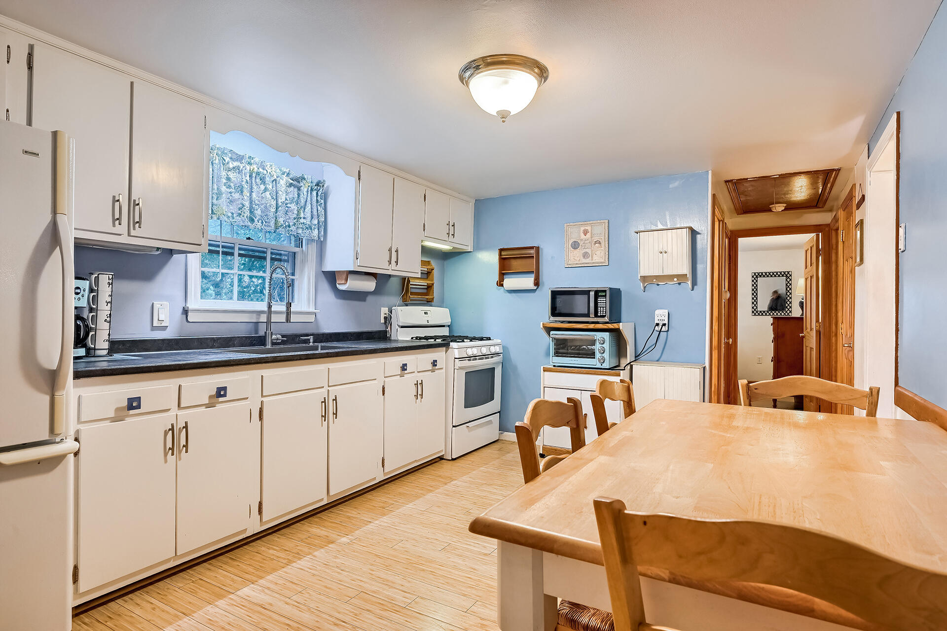 11 Mizzentop Lane Centerville, MA 02632 - Photo 6 of 18 a very nice looking kitchen with stainless steel appliances granite countertop a stove top oven a sink a dining table and chairs with wooden floor