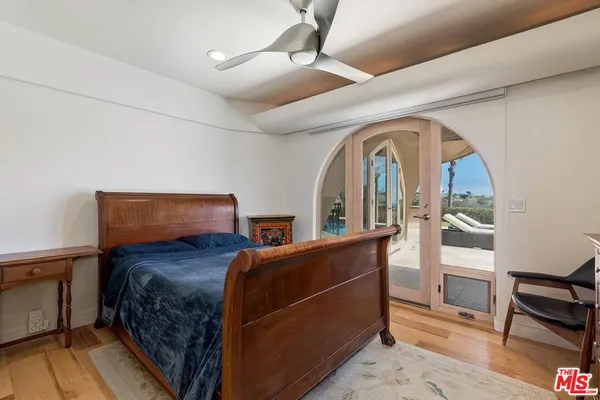 a bedroom with two beds and wooden floor