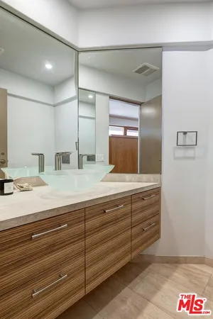 a bathroom with double vanity and a mirror