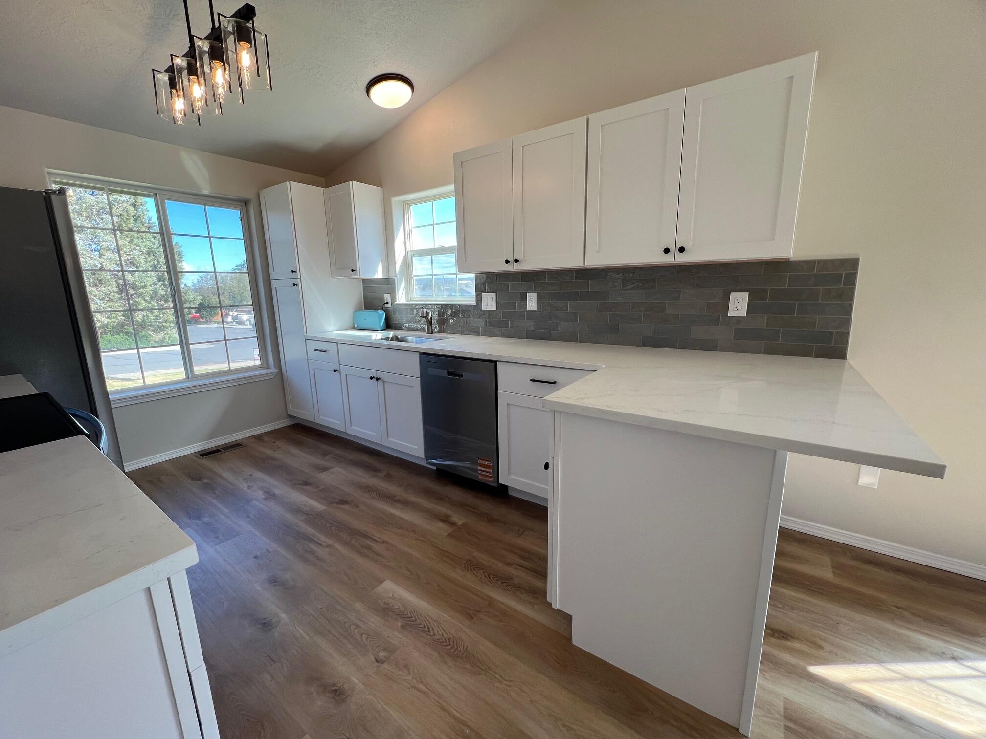 629 Deer Ridge Court Madras, OR 97741 - Photo 7 of 39 a kitchen with granite countertop a stove a sink a refrigerator and wooden floors