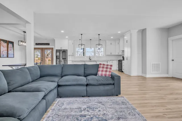 a large kitchen with cabinets a sink a window and stainless steel appliances