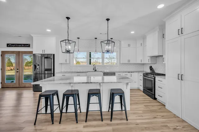 a kitchen with stainless steel appliances granite countertop a sink stove and refrigerator