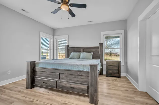 a bedroom with a bed and wooden floor