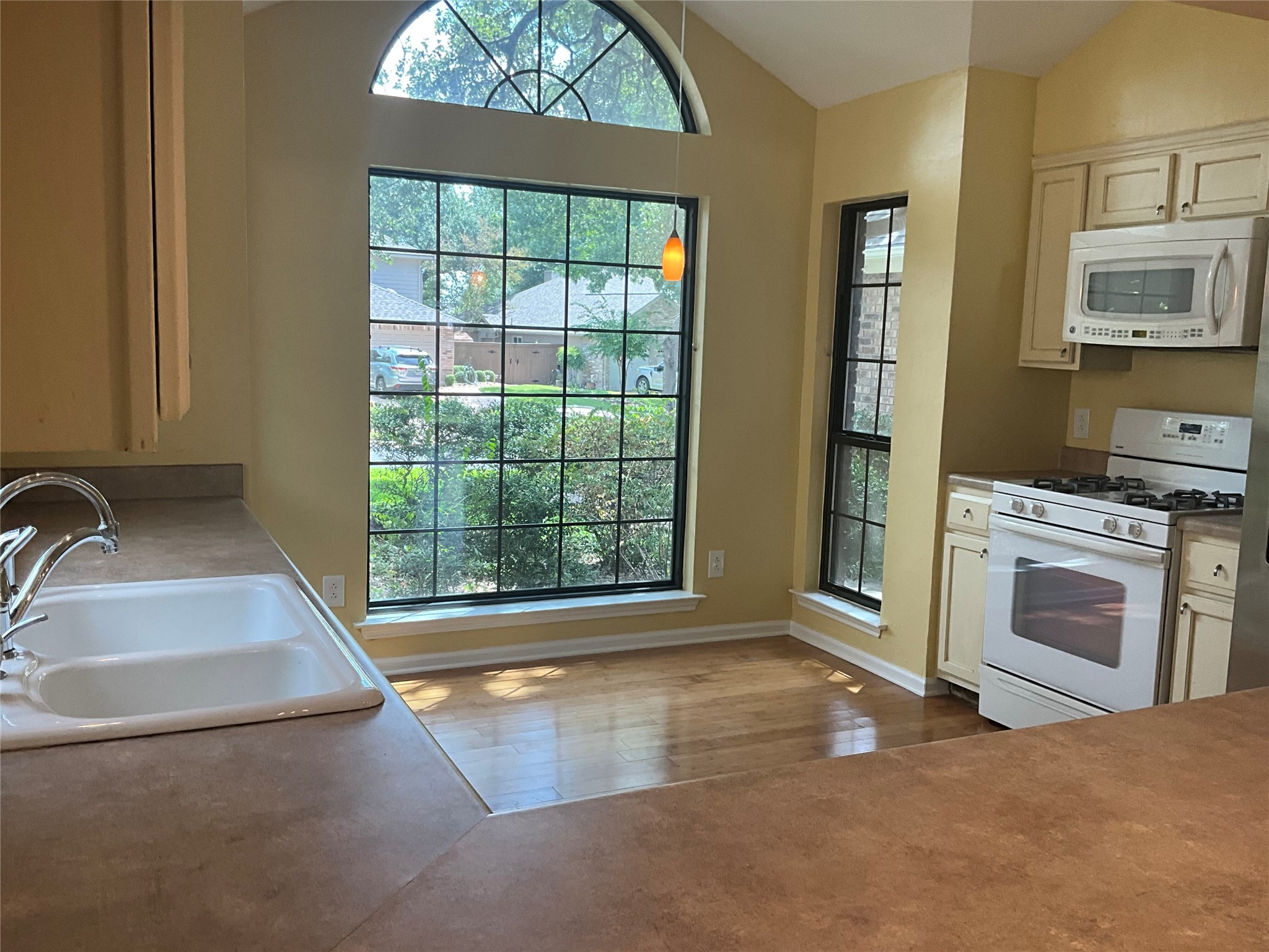 15702 Racine Cove Austin, TX 78717 - Photo 10 of 27 A well-lit kitchen with generous window views of the outdoors, offering both comfort and practicality.