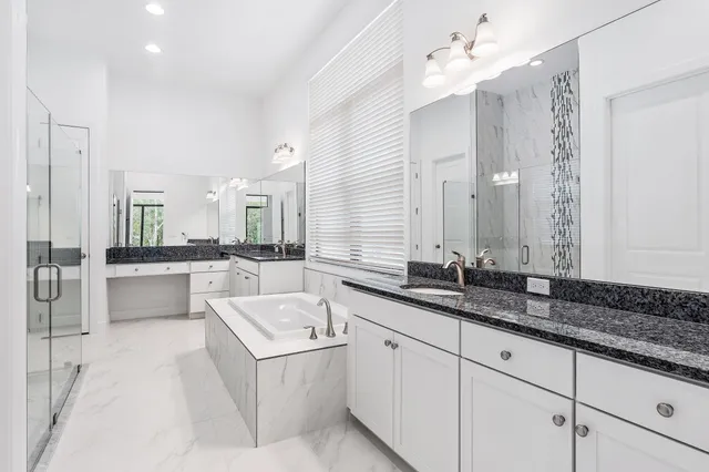 a large white kitchen with a sink large white cabinets and chandelier