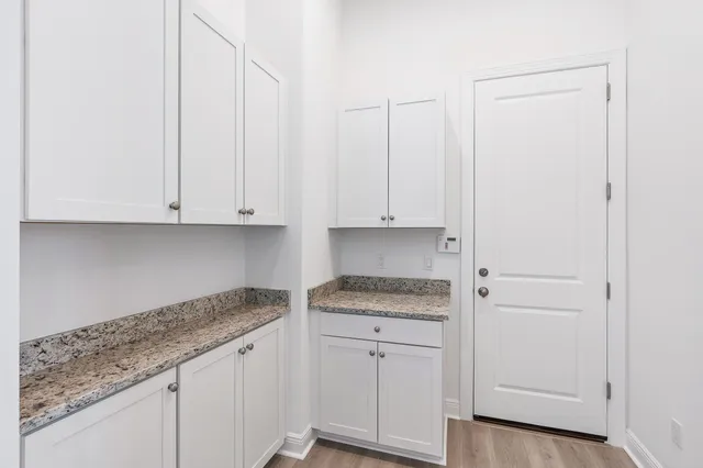 a kitchen with granite countertop white cabinets and a sink