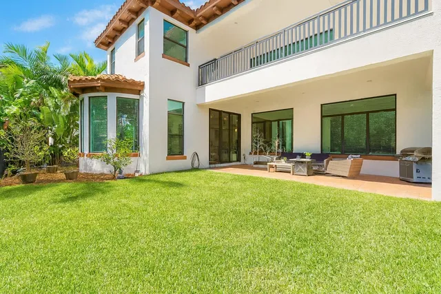 a view of a house with a backyard patio and swimming pool