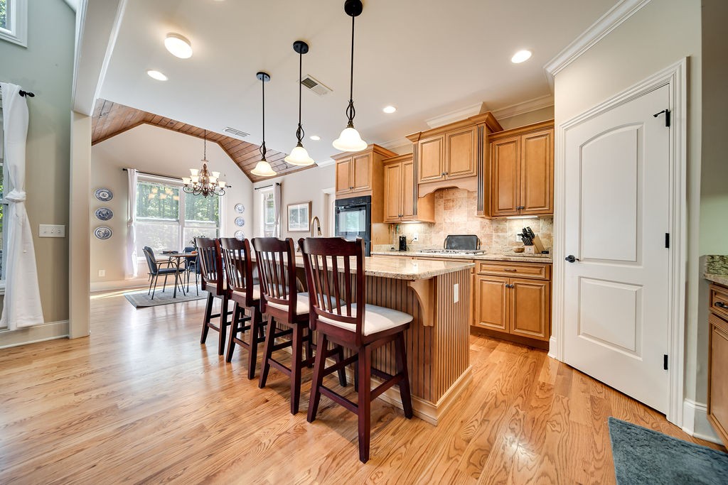 5751 Pinewood Road Franklin, TN 37064 - Photo 13 of 50 a open kitchen with stainless steel appliances granite countertop a stove a refrigerator a dining table and chairs with wooden floor