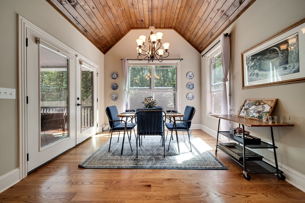 5751 Pinewood Road Franklin, TN 37064 - Photo 16 of 50 a dining room with wooden floor a chandelier a glass table and chairs
