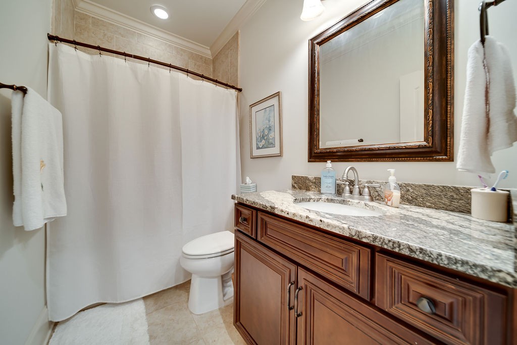 5751 Pinewood Road Franklin, TN 37064 - Photo 26 of 50 a bathroom with a granite countertop sink a toilet and a mirror