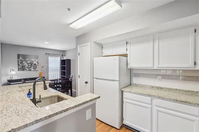 a kitchen with a sink refrigerator and cabinets
