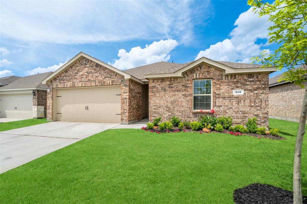 a front view of a house with a garden and yard
