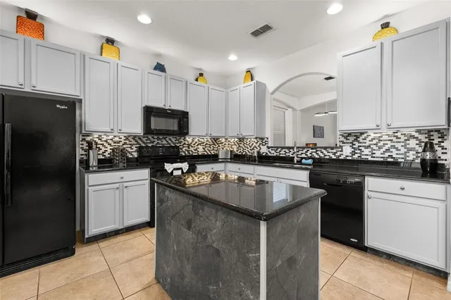 a bedroom with a bed a dresser and paintings on the wall
