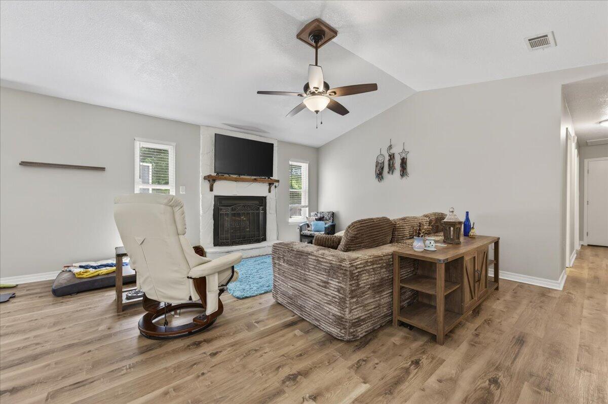 210 Shell Drive Crestview, FL 32536 - Photo 19 of 67 a living room with furniture a flat screen tv and a fireplace