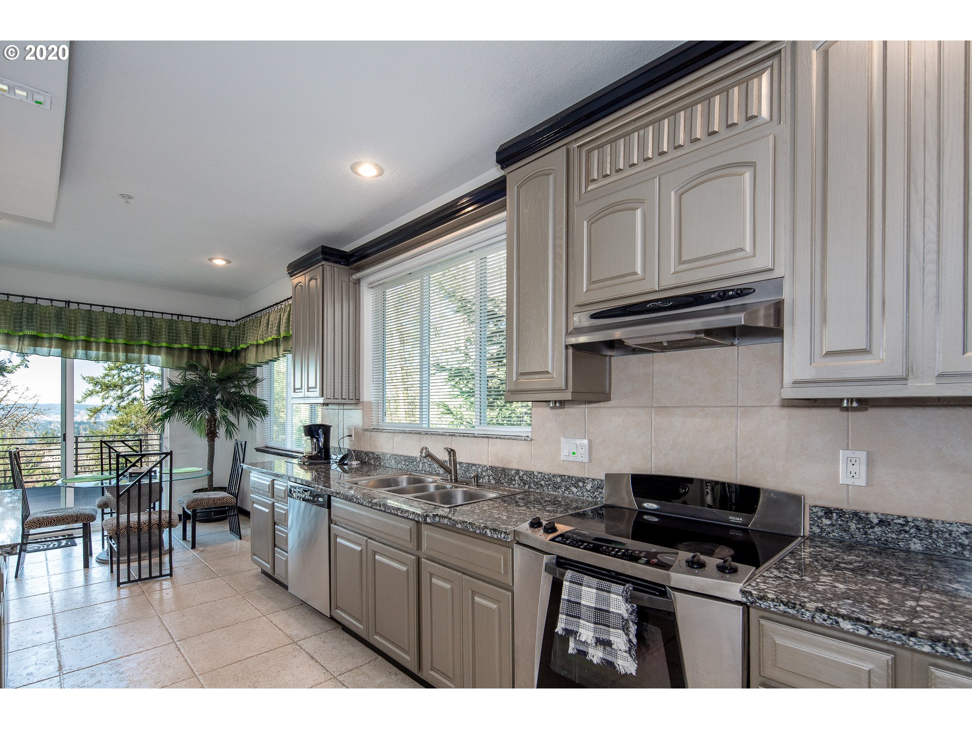 10301 Southeast Crescent Ridge Loop Happy Valley, OR 97086 - Photo 13 of 32 a kitchen with stainless steel appliances granite countertop a stove a sink and a granite counter tops