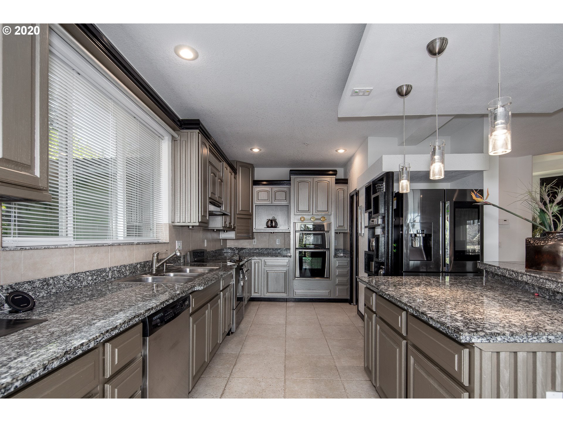 10301 Southeast Crescent Ridge Loop Happy Valley, OR 97086 - Photo 14 of 32 a kitchen with stainless steel appliances granite countertop a sink a stove and a refrigerator