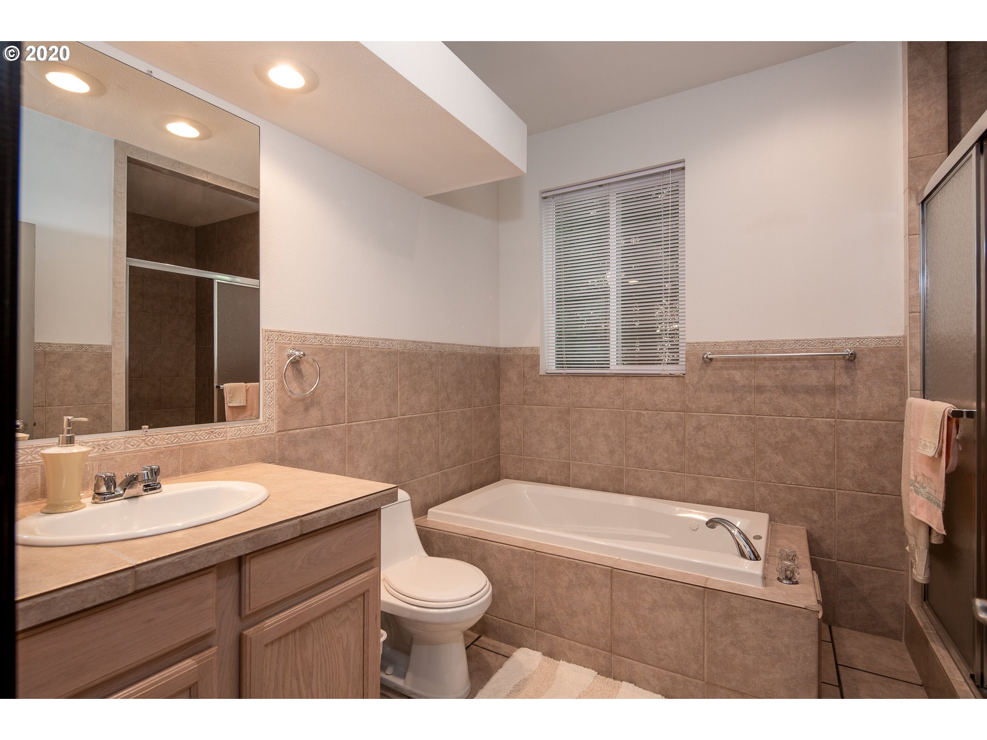 10301 Southeast Crescent Ridge Loop Happy Valley, OR 97086 - Photo 22 of 32 a bathroom with a sink a toilet and shower