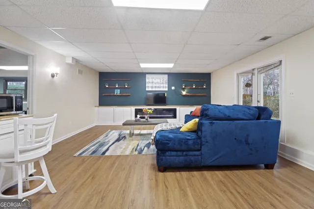 a living room with furniture a flat screen tv and a table