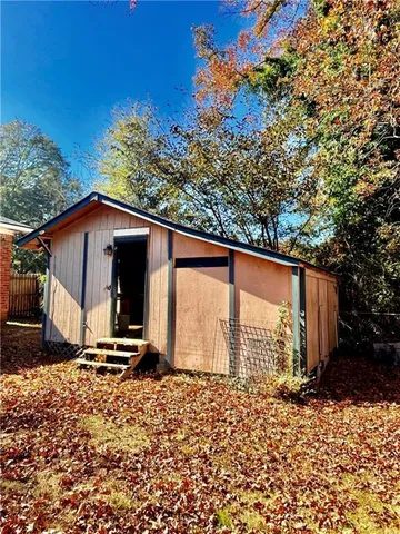 a view of backyard with wooden fence and large trees