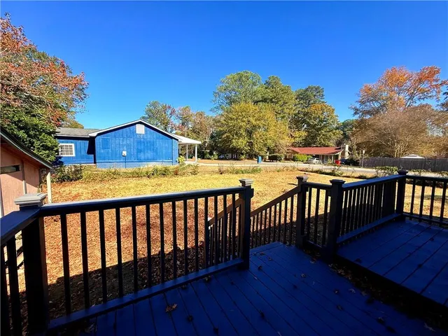 a view of a wooden deck and a backyard