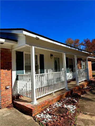 a view of a house with a small yard and wooden fence