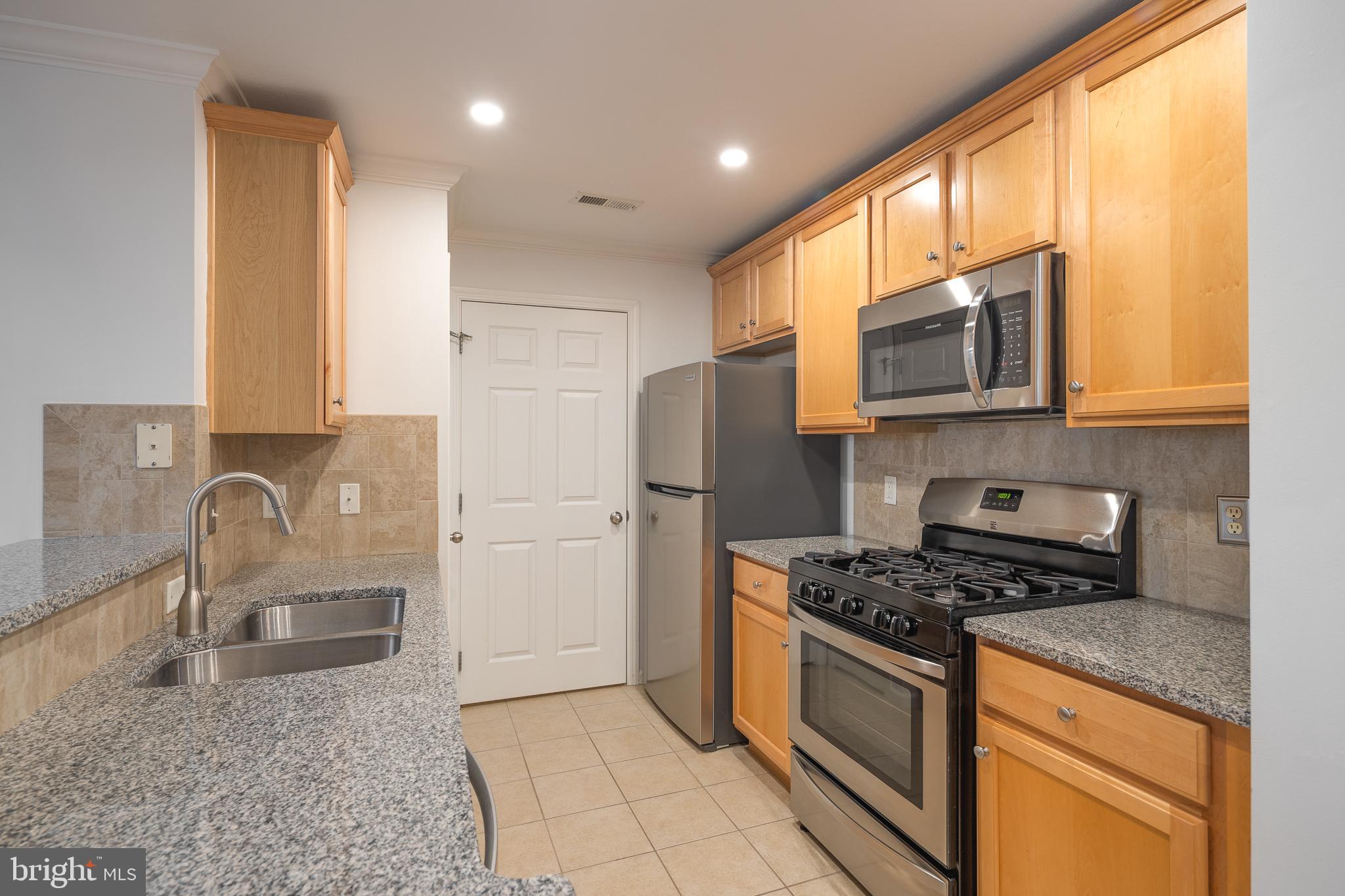 512 Sunset View Terrace Southeast, Unit 402 Leesburg, VA 20175 - Photo 13 of 30 a kitchen with stainless steel appliances granite countertop a stove a sink and a microwave