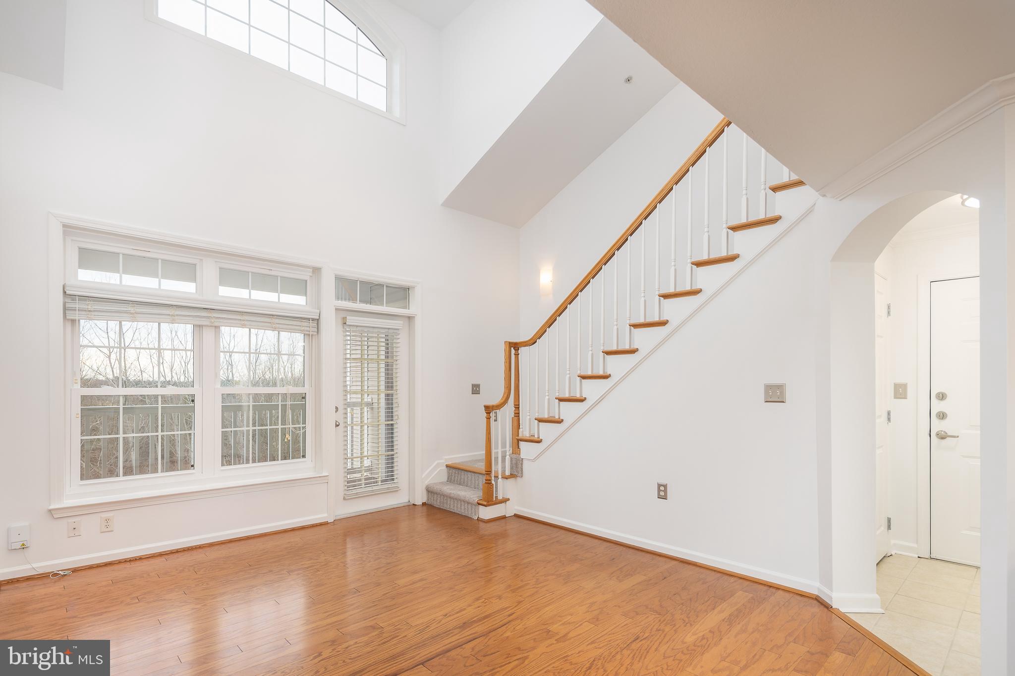 512 Sunset View Terrace Southeast, Unit 402 Leesburg, VA 20175 - Photo 7 of 30 a view of an empty room with wooden floor and windows