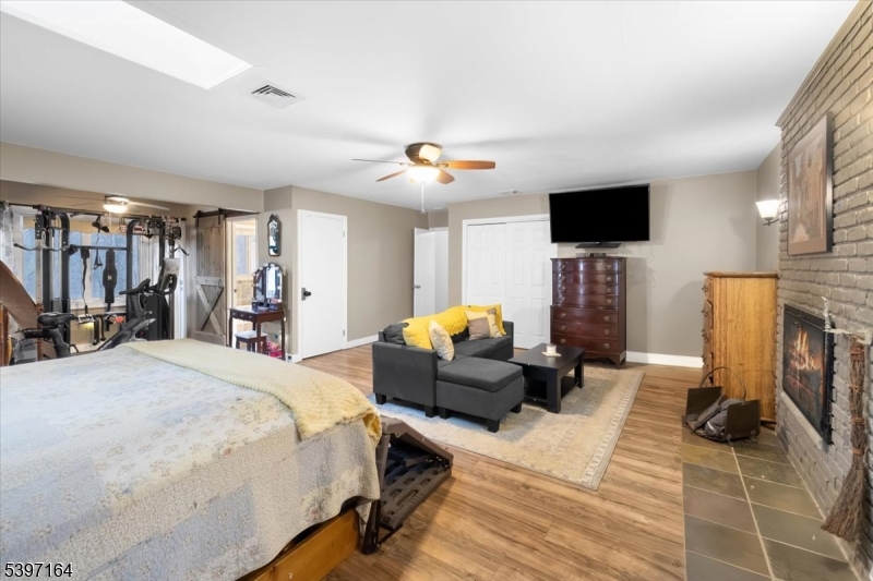 53 Pequot Road Ringwood, NJ 07456 - Photo 22 of 35 a bedroom with a bed a flat screen tv and a chandelier