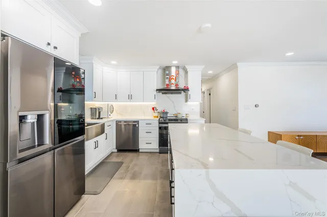 a kitchen that has a lot of white table and chairs