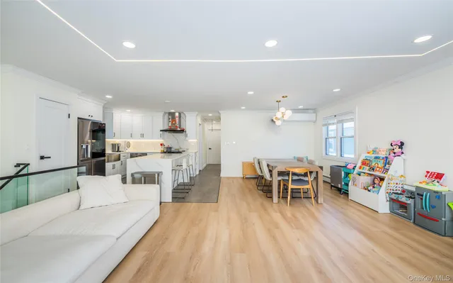 a living room with furniture and kitchen view with wooden floor