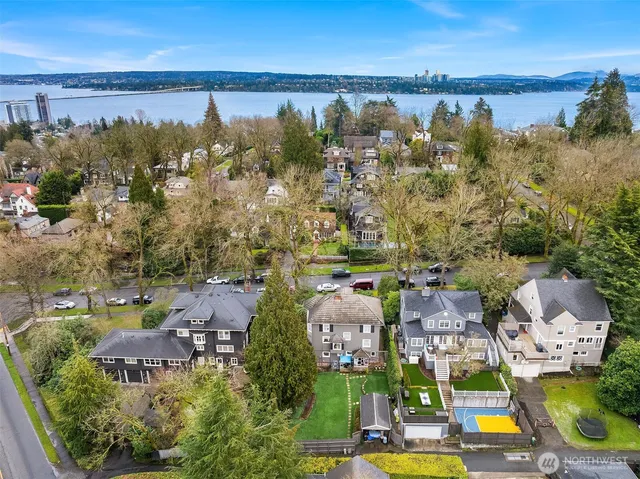 an aerial view of residential houses with outdoor space and lake view