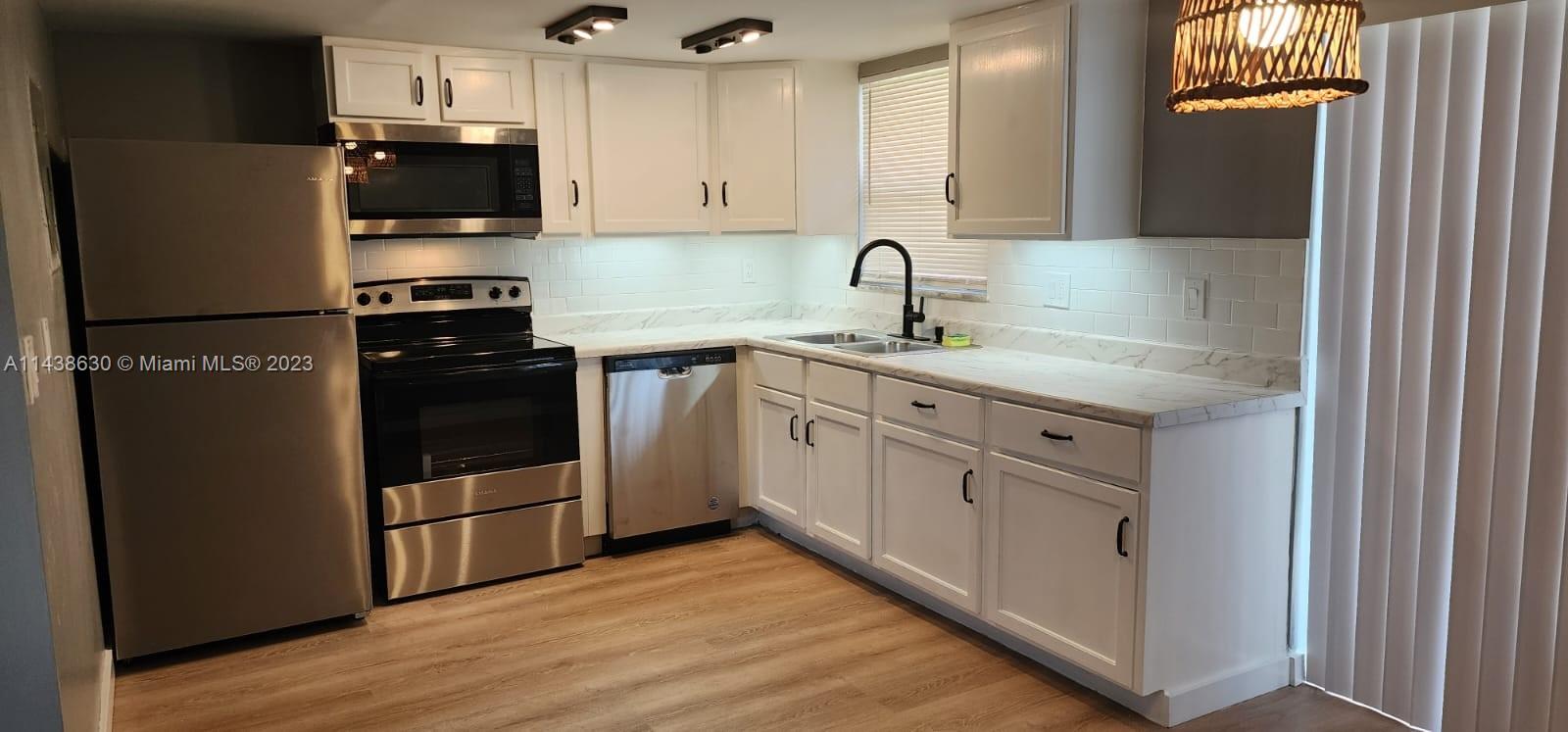 5321 Northwest 27th Street, Unit A4 Lauderhill, FL 33313 - Photo 1 of 19 a kitchen with white cabinets and stainless steel appliances