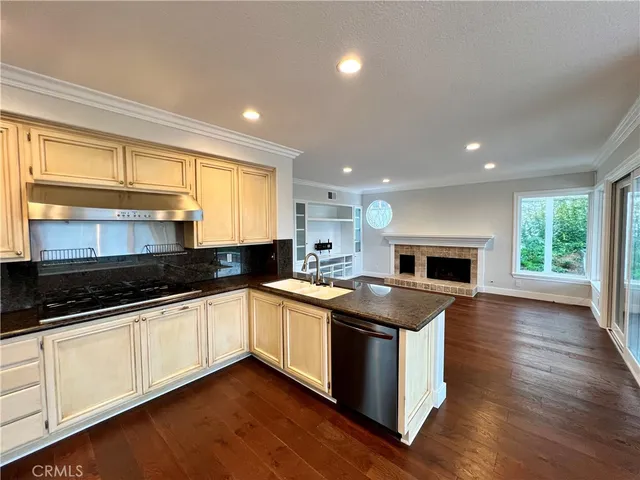 a kitchen with stainless steel appliances granite countertop wooden cabinets and a sink